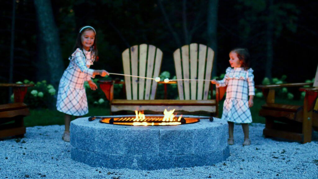 Photo of children roasting marshmallows at a fire pit